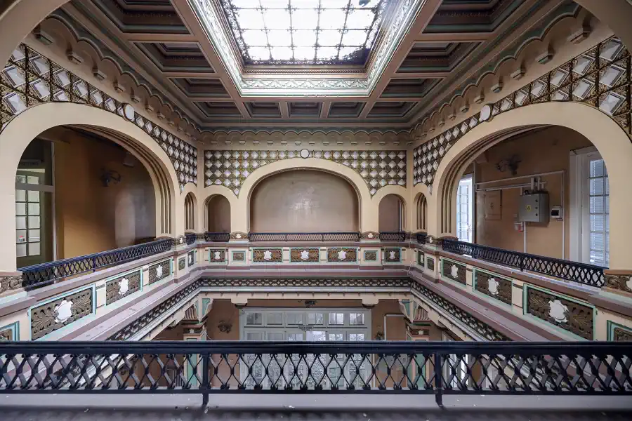 Galerie centrale de Casa Băileșteanu avec arcs décoratifs, garde-corps ouvragés et verrière