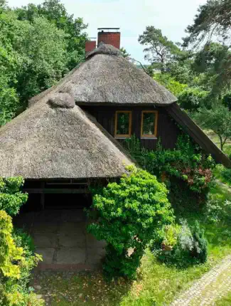 Maison de campagne au toit de chaume en situation isolée près de la mer Baltique